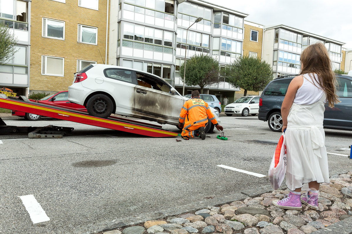 A burned out car being pulled away in Malmö